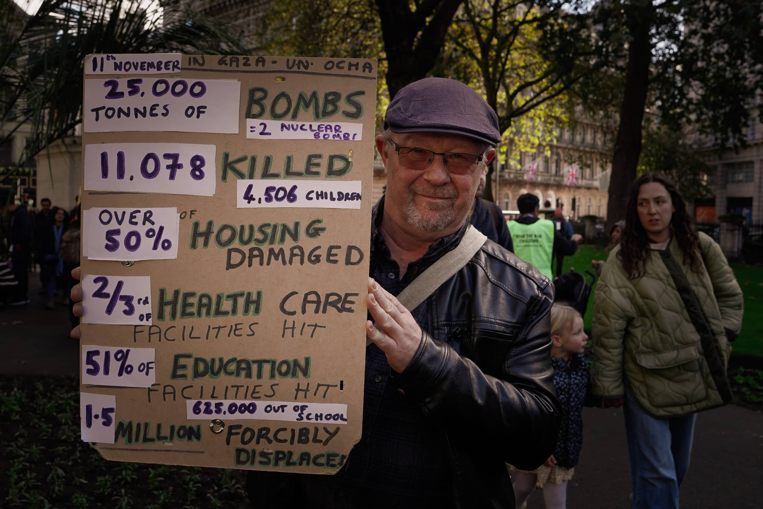 Protestor holding a sign showing the damage, in numbers, that the Israeli siege has had on Palestinians.